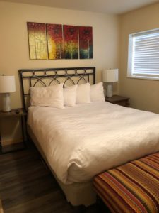 Condo bedroom with queen bed and lamps