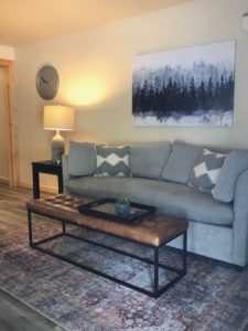 Gray couch and brown bench in condo living room