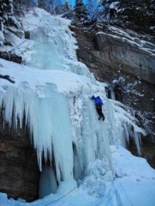 Man ice climbing rock face