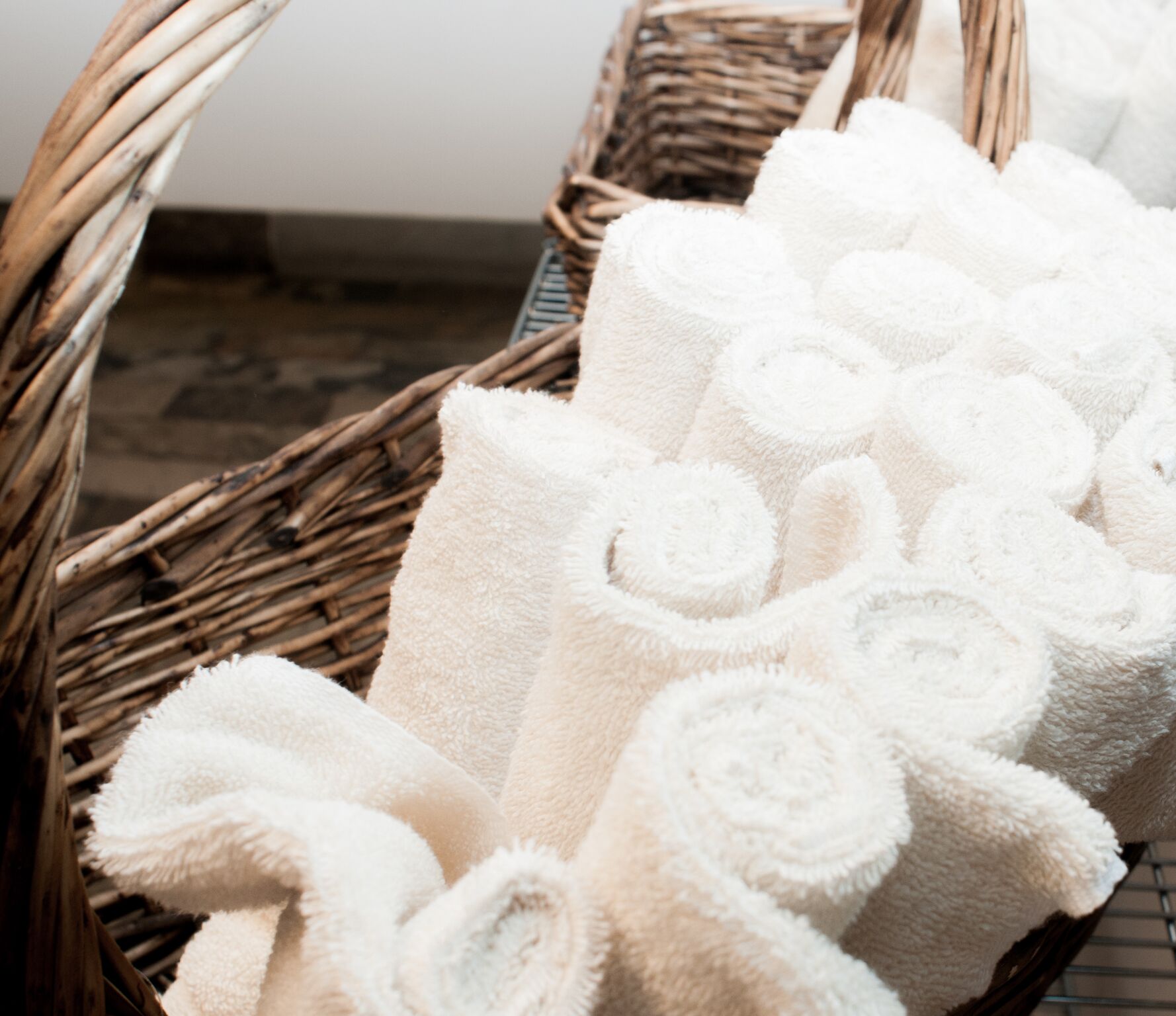 Brown basket with white towels inside