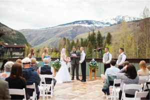 Couple saying wedding vows with mountain background