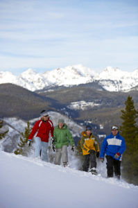 Family snowshoeing on mountain slope