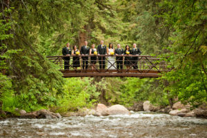 Wedding party standing on bridge over the river