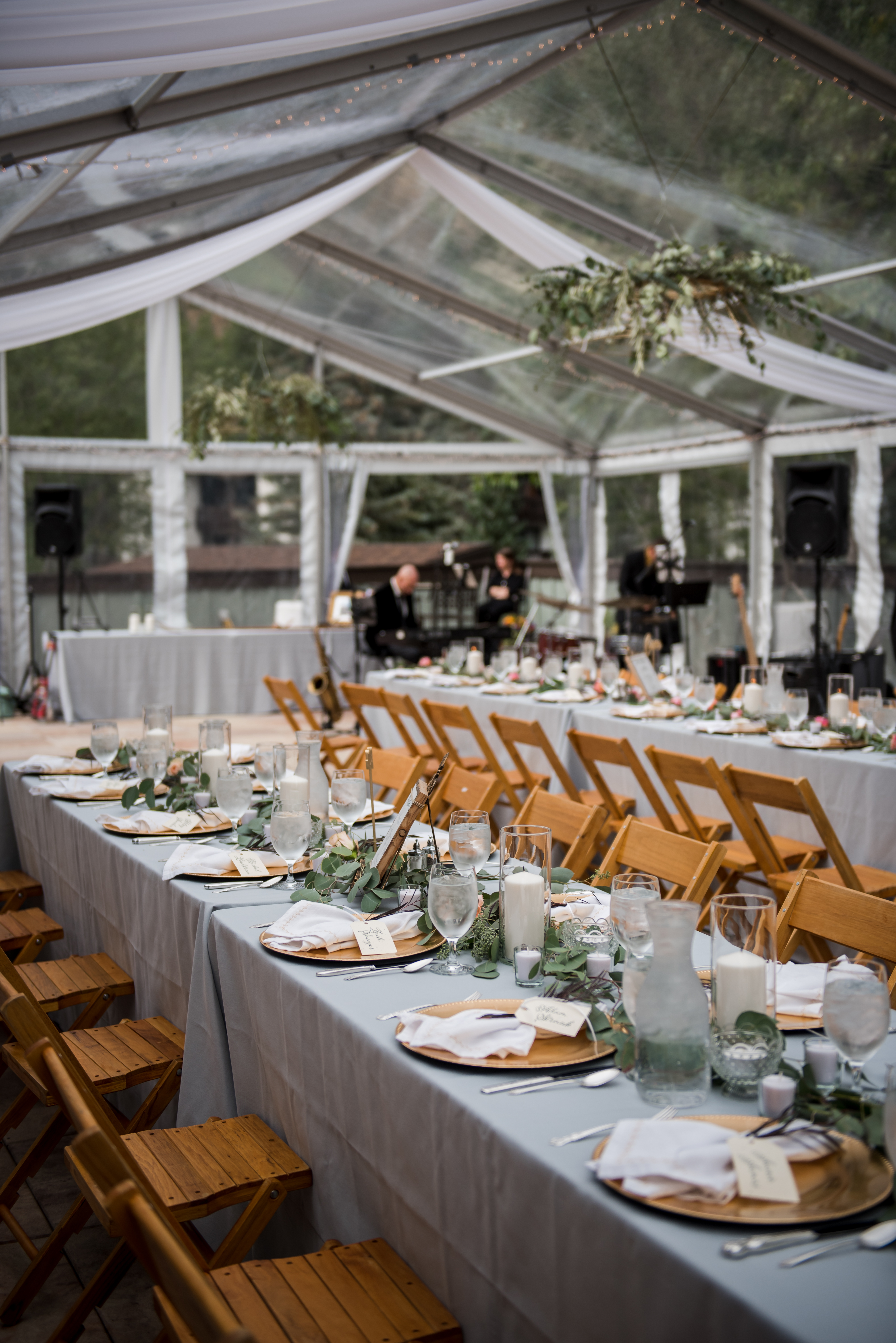 Long covered tables and chairs under open tent