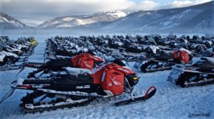 Snowmobiles ready in parking area