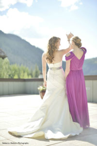 Bride and Bridesmaid posing on deck with mountain view