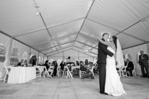 Husband and wife dance under tent in black and white
