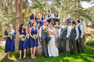 Wedding party standing in front of boulder
