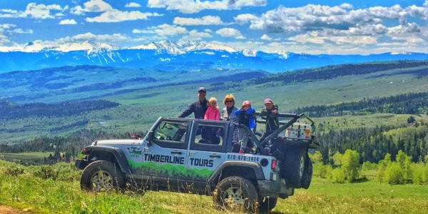 Timberline Tour van on mountain with family standing