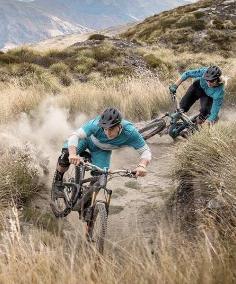 Two guys riding mountain bikes down a trail