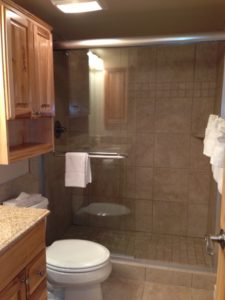 Toilet next to shower with sliding glass door